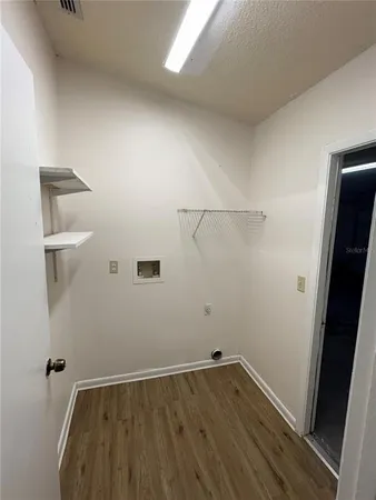 an empty room with wooden floor and cabinet