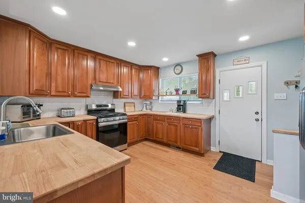 a kitchen with stainless steel appliances granite countertop a sink refrigerator and cabinets