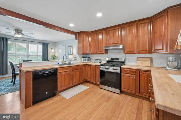 a kitchen with a sink wooden cabinets and stainless steel appliances