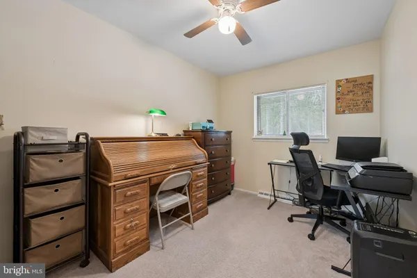 a bedroom with a workspace and a window