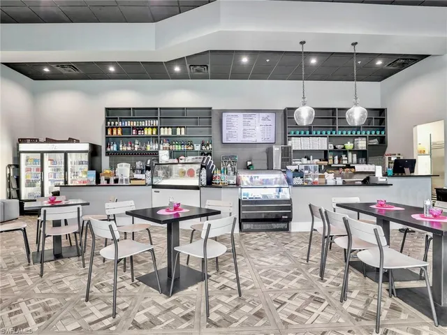 a view of a dining hall with lots of furniture and a large window
