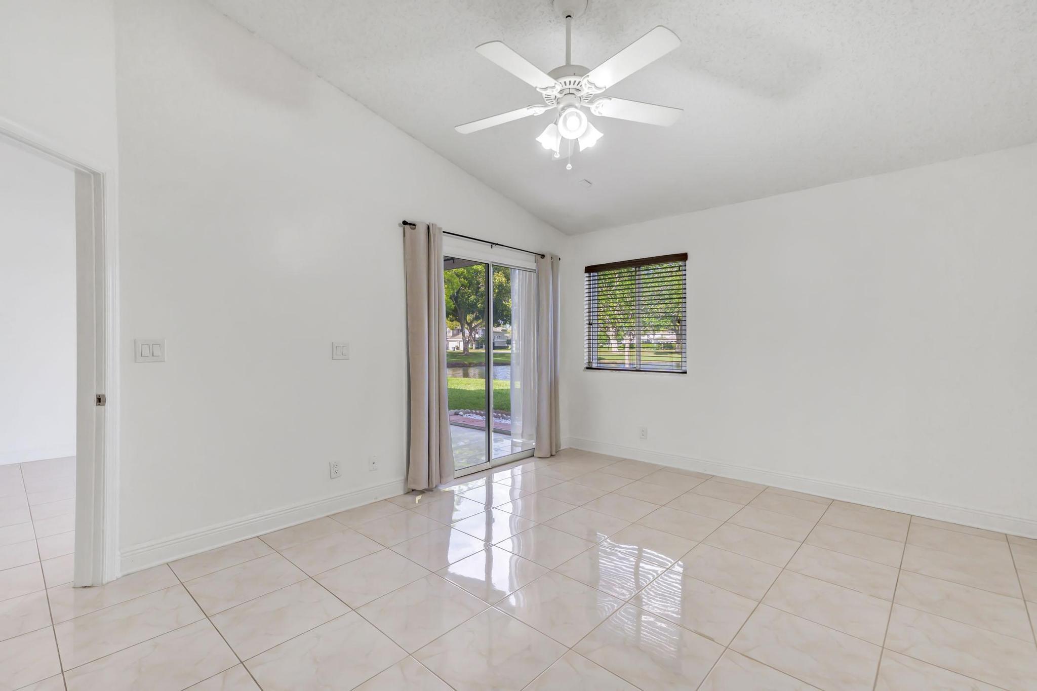 9130 Vineland Court, Unit C Boca Raton, FL 33496 - Photo 17 of 81 an empty room with windows and chandelier fan