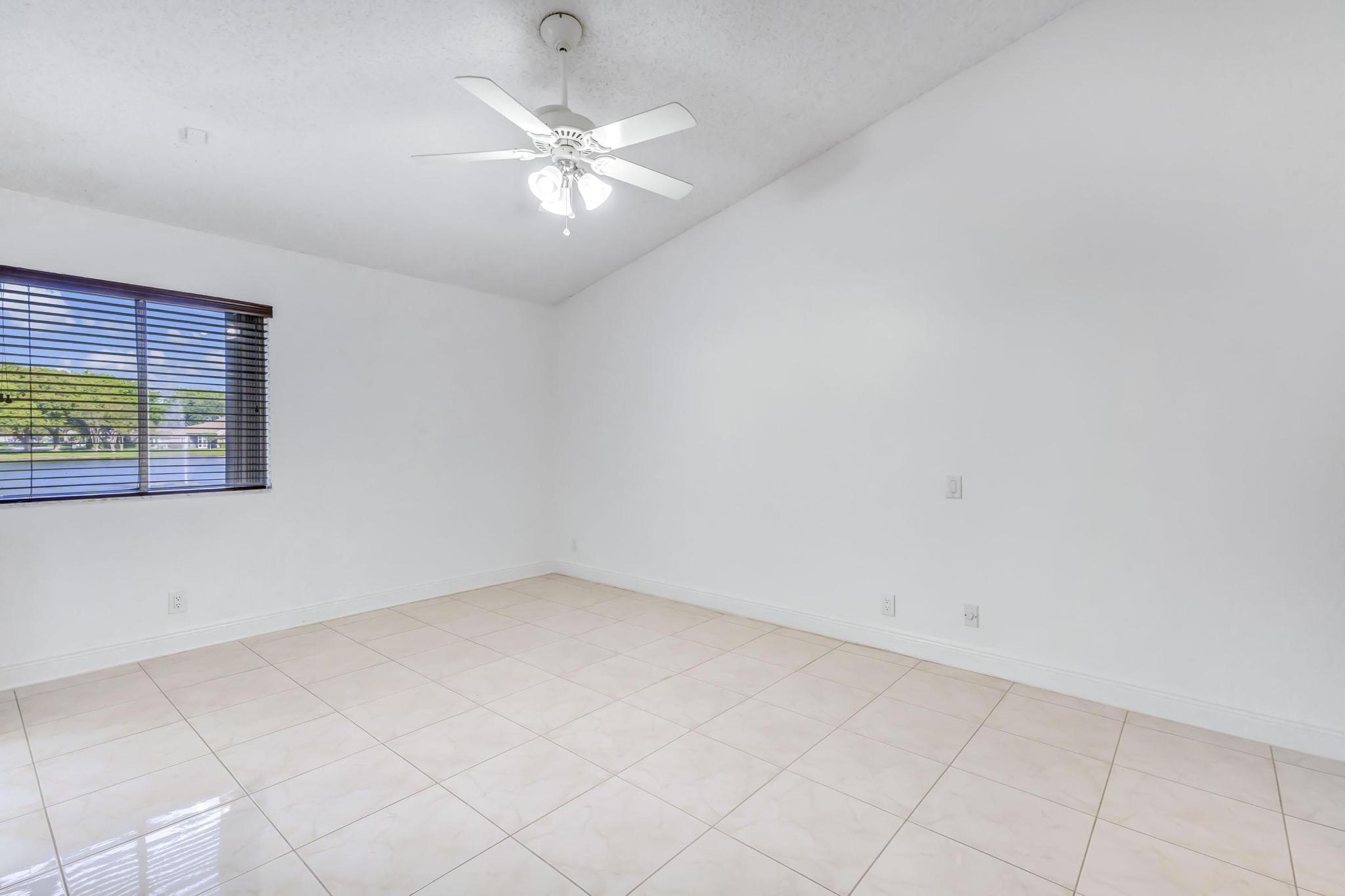 9130 Vineland Court, Unit C Boca Raton, FL 33496 - Photo 18 of 81 an empty room with a chandelier fan