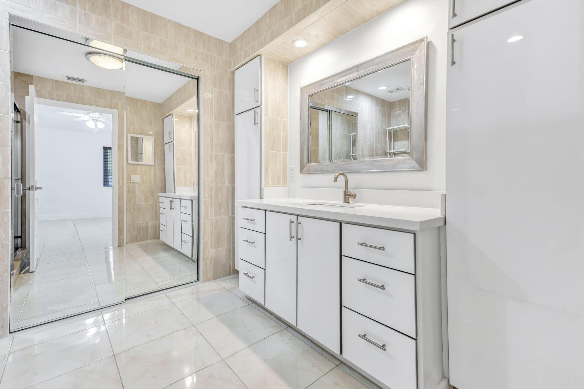 9130 Vineland Court, Unit C Boca Raton, FL 33496 - Photo 22 of 81 a spacious bathroom with a shower sink and mirror