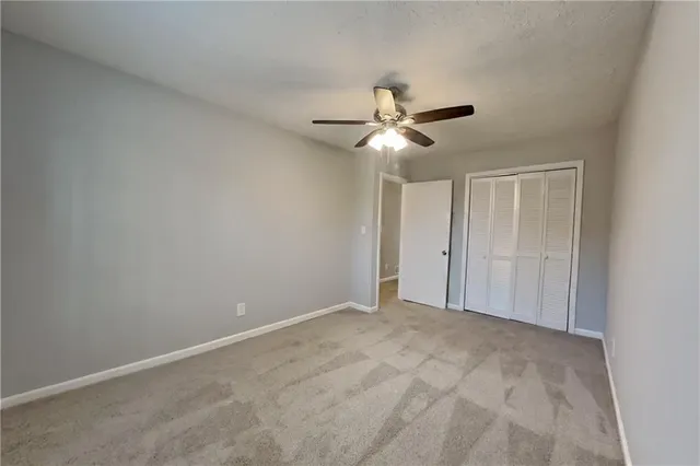 a view of an empty room with a chandelier fan