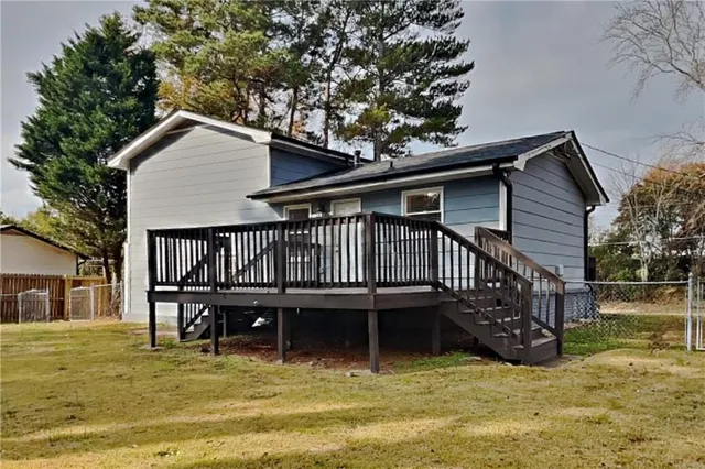 a view of a house with a wooden deck and a swimming pool