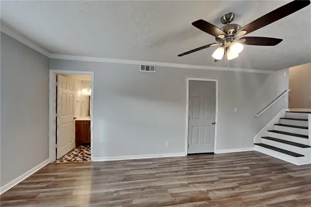 wooden floor in an empty room with a ceiling fan