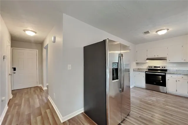 a kitchen with stainless steel appliances a refrigerator and a stove top oven