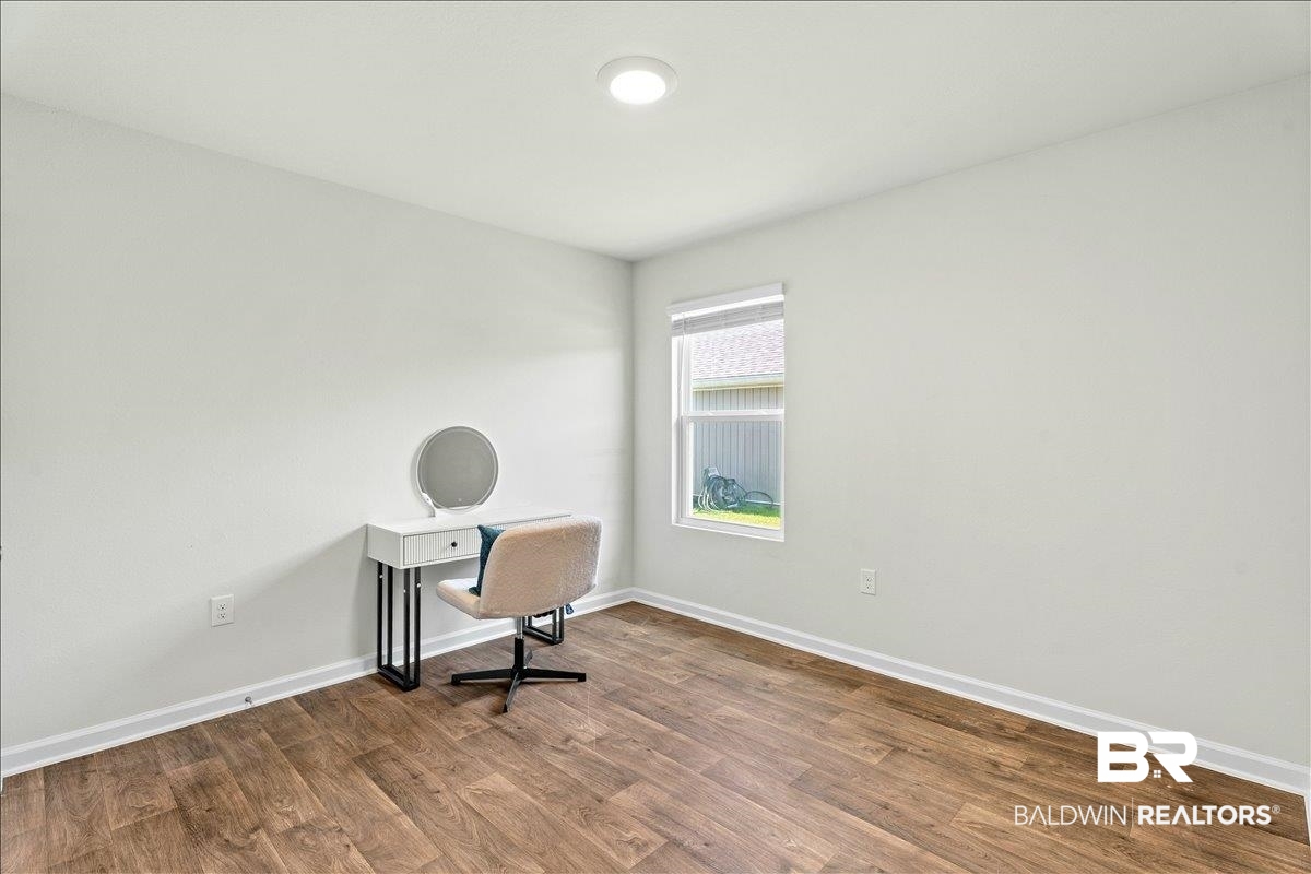 23641 Unbridled Loop Daphne, AL 36526 - Photo 23 of 40 Spacious room featuring wood-finish flooring, white baseboards, and a single window with blinds