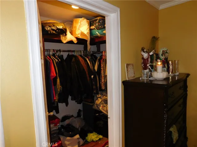 a view of walk in closet with clothes and shoes
