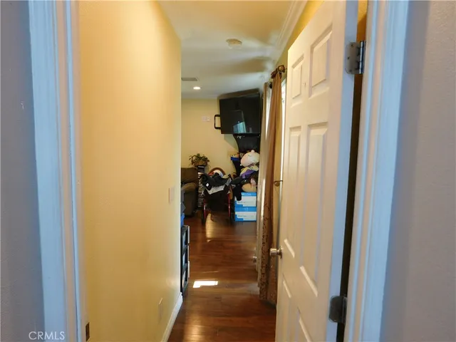 a hallway with wooden floor fireplace and living room
