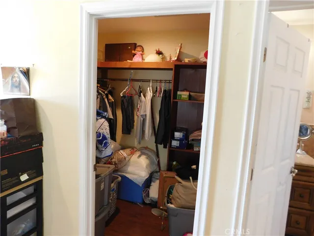 a view of walk in closet with clothes and shoes