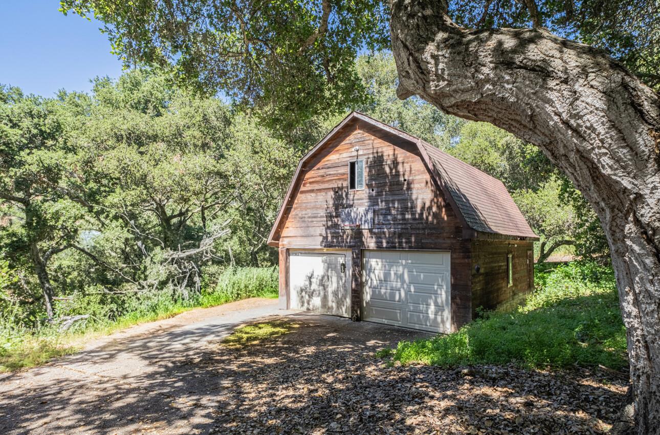11521 Hidden Hills Road Carmel Valley, CA 93924 - Photo 5 of 26 a view of a wooden house with large trees
