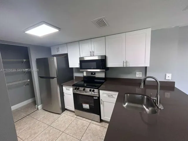 a kitchen with stainless steel appliances granite countertop a refrigerator stove and microwave