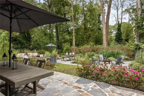 a view of a chair and table in backyard of the house