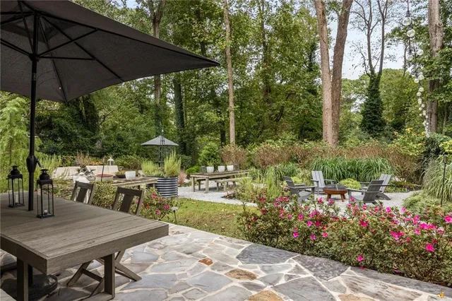 a view of a chair and table in backyard of the house