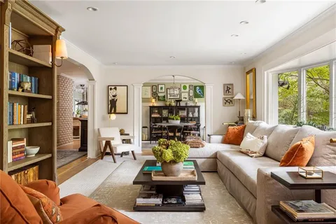 a living room with furniture and a book shelf