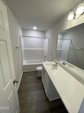 a bathroom with a double vanity sink mirror and bathtub
