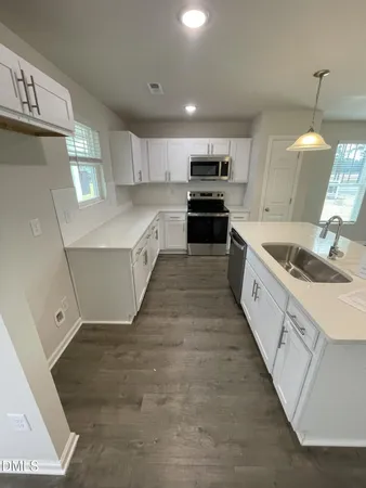 a large kitchen with stainless steel appliances kitchen island granite countertop a sink and cabinets
