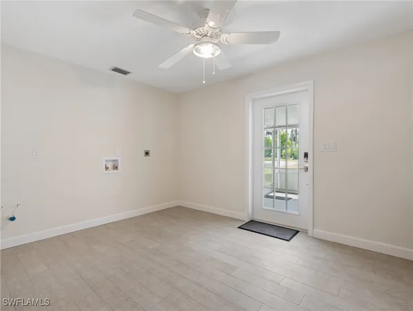 an empty room with closet and a ceiling fan
