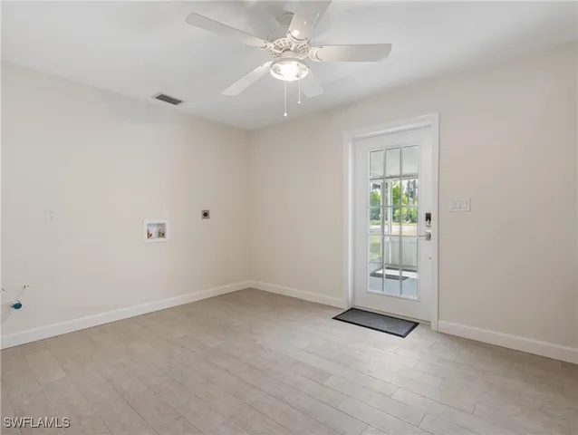 an empty room with closet and a ceiling fan