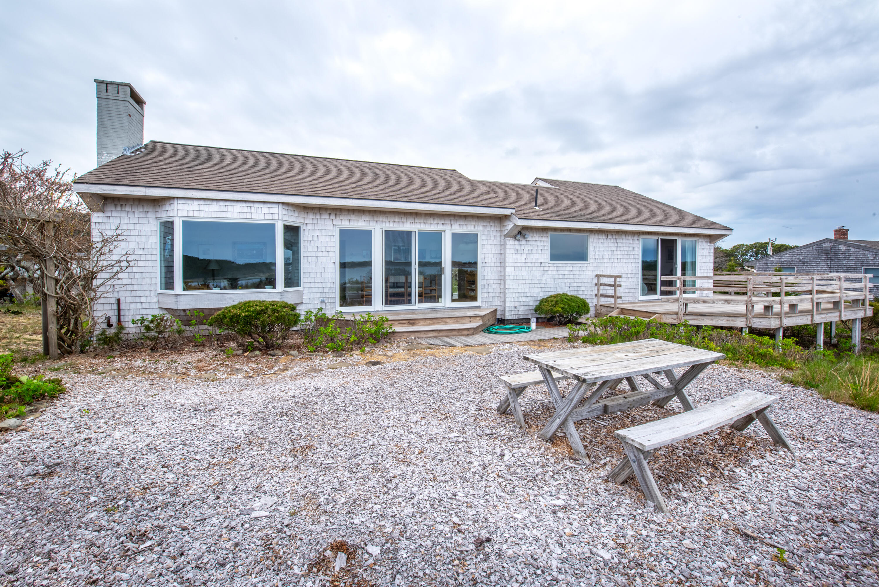 40 Ione Road Wellfleet, MA 02667 - Photo 8 of 30 a house view with a sitting space fire pit and chairs in front of the house