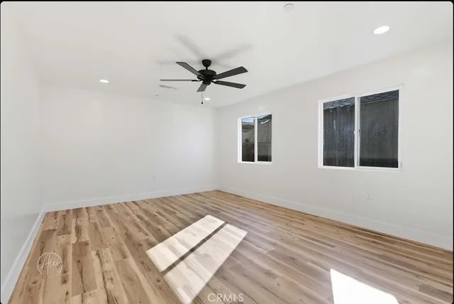 a view of empty room with wooden floor and window