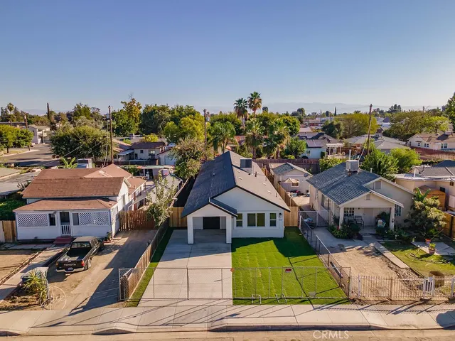 a view of an empty room with kitchen appliances and a ceiling fan