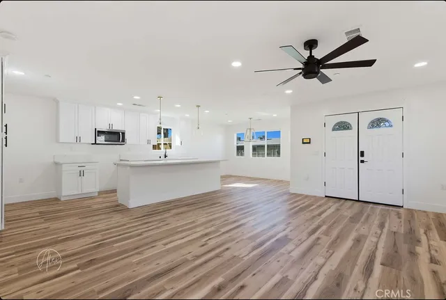 a view of a kitchen with a sink and wooden floor
