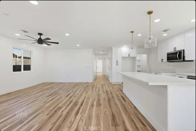 a large kitchen with kitchen island a sink wooden floor and a stove