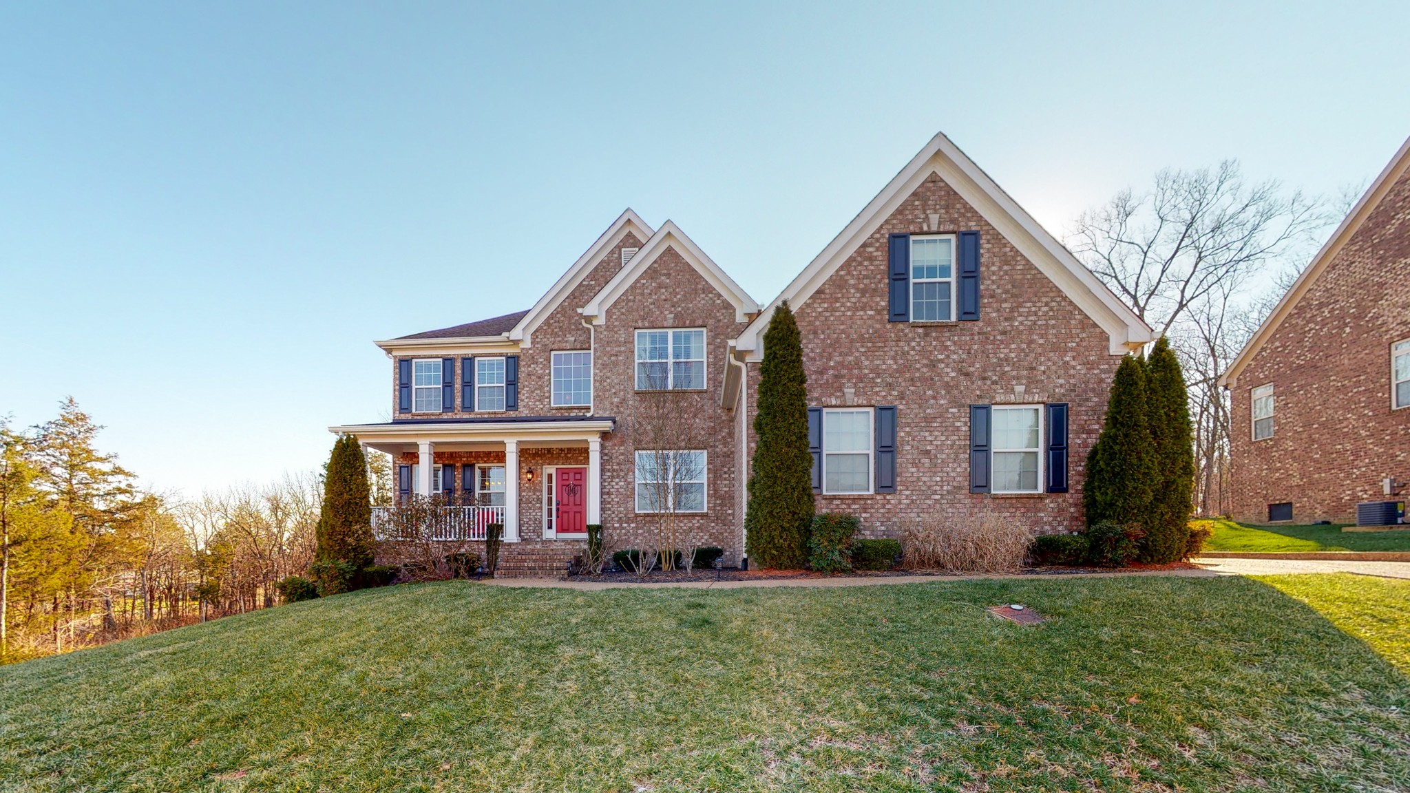 a front view of a house with a yard and trees