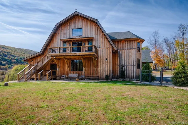 a view of a big house with a big yard and large trees