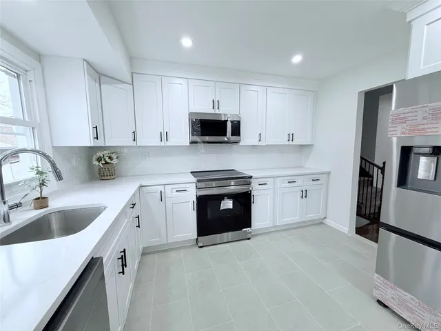 a kitchen with a sink stove and microwave