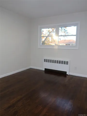a view of a livingroom with wooden floor and window