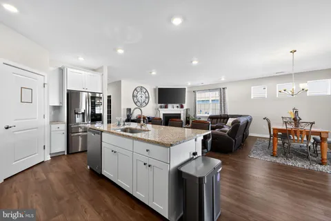 a open kitchen with stainless steel appliances granite countertop a lot of counter top space and a wooden floor