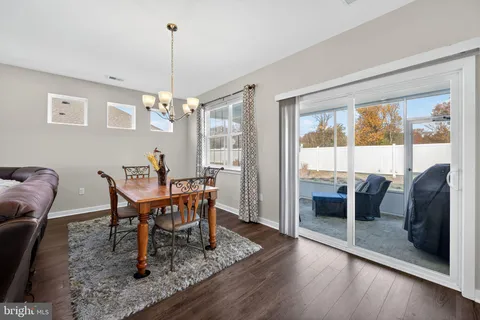 a dining room with furniture a chandelier and wooden floor