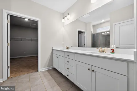 a bathroom with double sink and a mirror