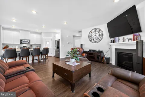 a living room with furniture a flat screen tv and kitchen view