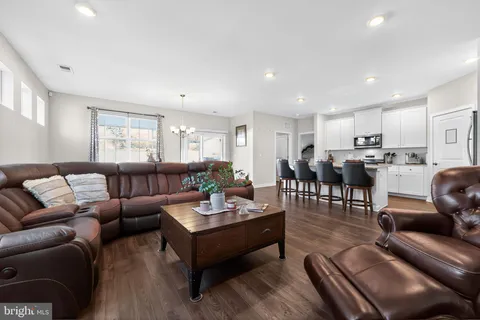a living room with furniture kitchen and a table