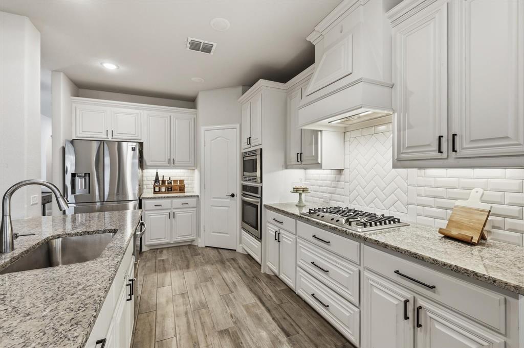 924 Timber Ridge Drive Justin, TX 76247 - Photo 12 of 32 White cabinetry with dark hardware and light-toned countertops