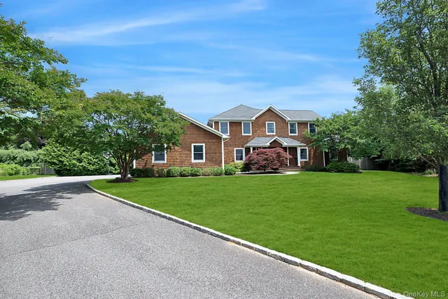 a view of a big house with a big yard and large trees