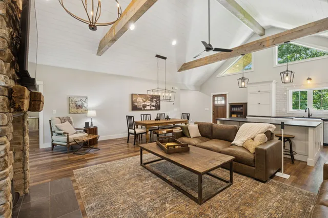 a kitchen with stainless steel appliances granite countertop a sink a stove and chairs