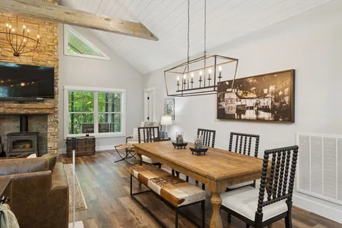 a kitchen with stainless steel appliances granite countertop a refrigerator a sink dishwasher a stove and white countertops with wooden floor