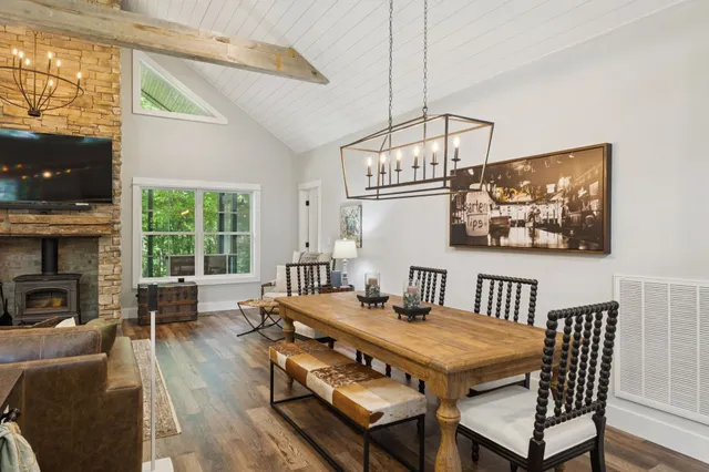 a kitchen with stainless steel appliances granite countertop a refrigerator a sink dishwasher a stove and white countertops with wooden floor