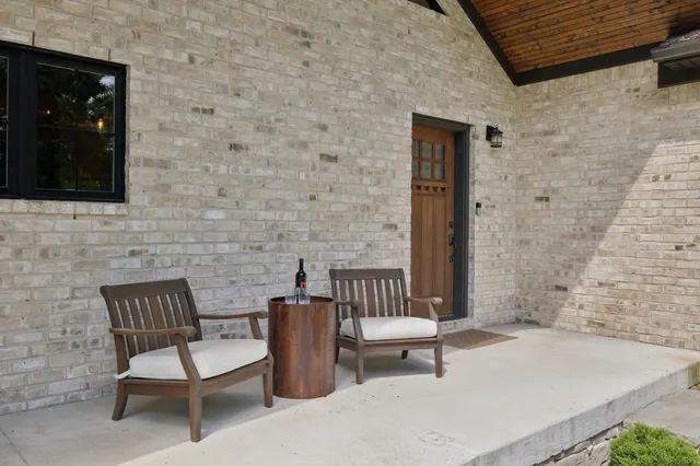 a living room with furniture a fireplace a lamp and a large window