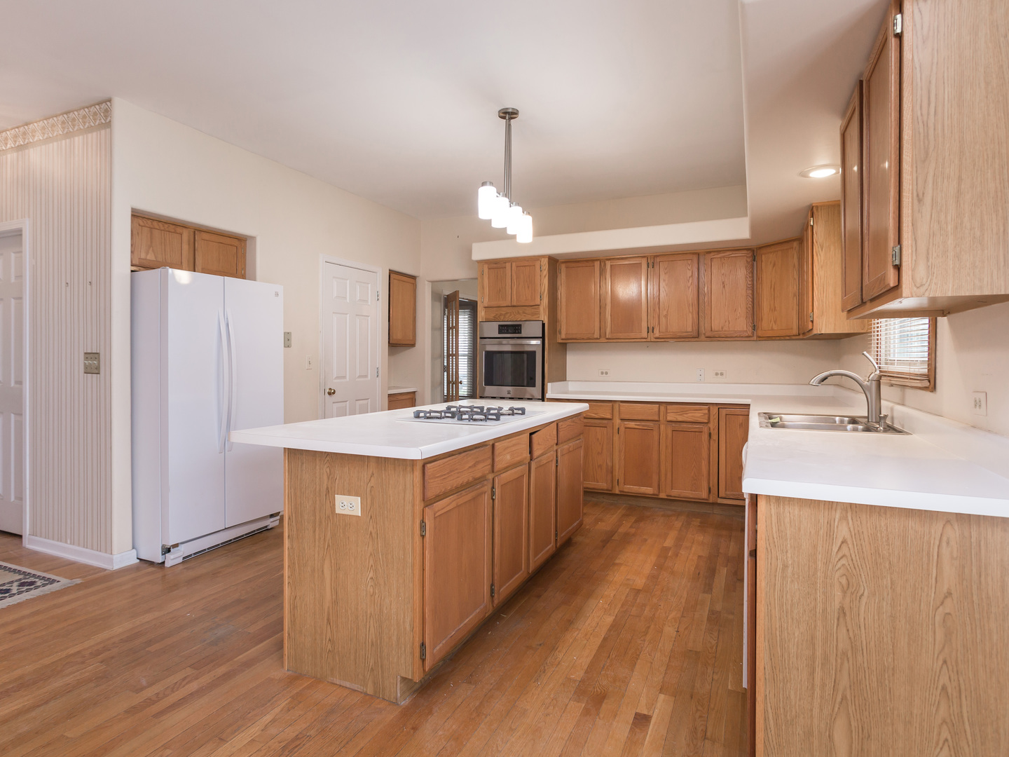 1415 Stonegate Road Algonquin, IL 60102 - Photo 13 of 49 a kitchen with kitchen island granite countertop wooden floors and white cabinets