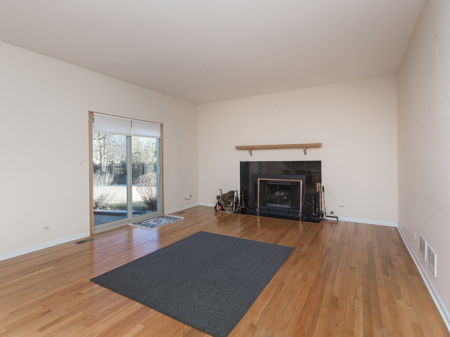 1415 Stonegate Road Algonquin, IL 60102 - Photo 15 of 49 an empty room with wooden floor and fireplace
