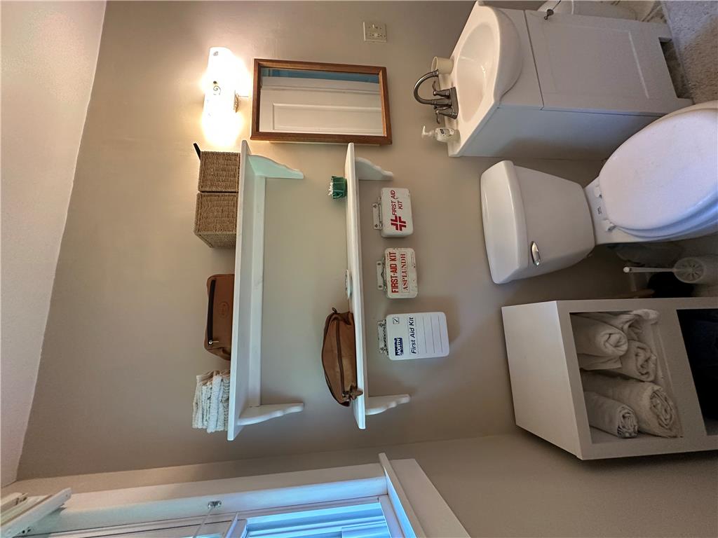 10 Kizer Pond Road Lake Ariel, PA 18436 - Photo 17 of 48 A compact and functional bathroom features a pristine white sink and toilet, complemented by practical wall-mounted shelving.