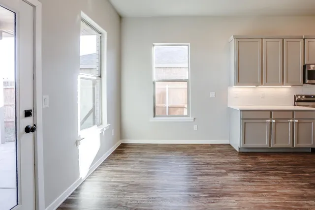 a view of a kitchen with wooden floor and a window
