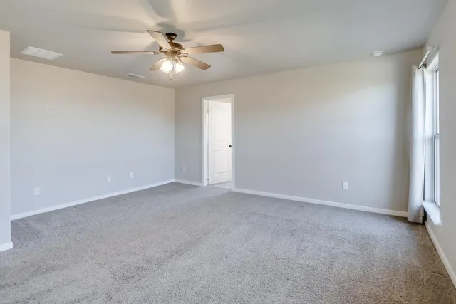 a view of an empty room with a ceiling fan